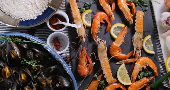 Dolly top down view of ingredient for a Spanish seafood paella: mussels, king prawns, langoustine, haddock