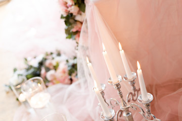Candles near the wedding table in ivory colors