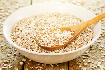 Uncooked oatmeal and wooden spoon