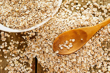 Uncooked oatmeal and wooden spoon