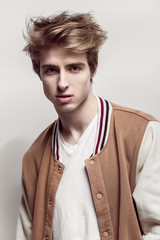 Young fashionable and Handsome man poses at white background in fancy clothes