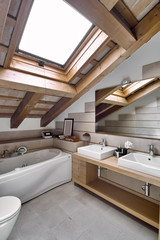 interior view of a modern bathroom in the attic room in foreground the countertop washbasin
