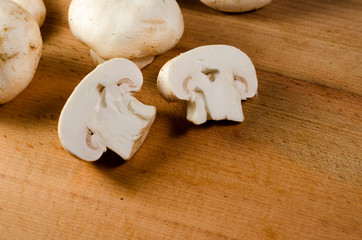 White champignon mushrooms on a wooden table