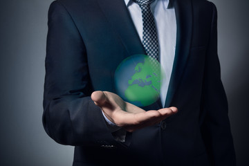 businessman in a suit holding planet earth. Planet earth in the hands. Protect the planet earth.