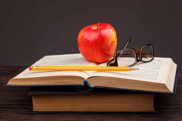 Education's equipment: books, pencil, apple and glasses