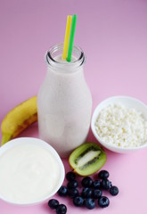 Fresh colorful vitamin breakfast yogurt cocktail with fruits kiwi banana and berries in glass bottle