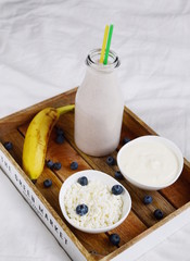 Fresh colorful vitamin breakfast yogurt cocktail with fruits kiwi banana and berries in glass bottle