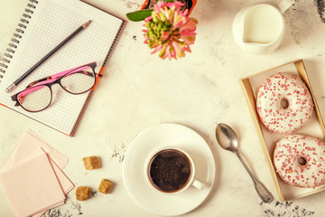 Obraz na płótnie Canvas Notepad, donuts and coffee on white table.