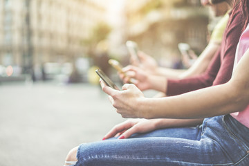Group of students watching smart mobile phones in university break