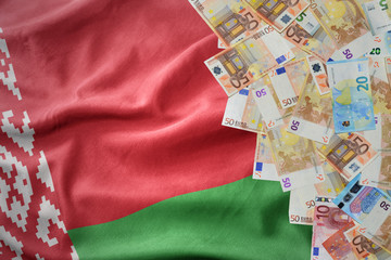 euro money banknotes on the waving national flag of belarus.
