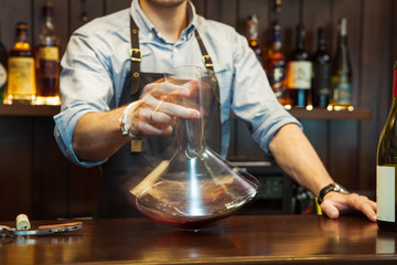 Bartender decanting wine without disturbing the sediment