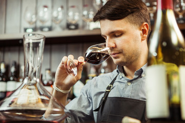 Male sommelier tasting red wine