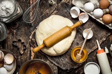 Dough background. Fresh dough with various ingredients on a wooden table.