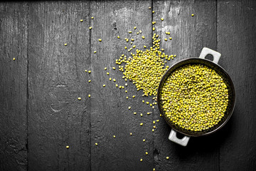 Green beans in a bowl . On the black wooden table.