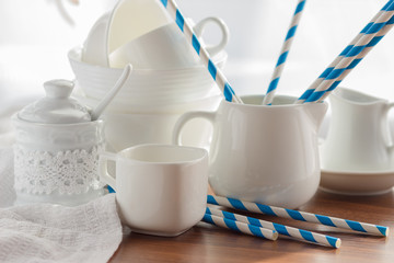 Set of white empty tableware on the wooden background