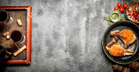 Meat grill. Fried pork in the pan with red wine. On rustic background.