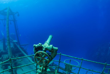 A water cannon points into the deep blue ocean that surrounds this shipwreck in the caribbean sea. The stern section of the vessel can be sen with its superstructure © drew
