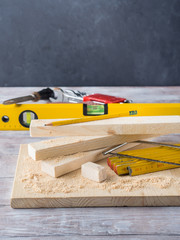 Wooden board with tools for manual measuring cutting - meter, level, pencil. Bricolage hand made DIY design craft project. Black background