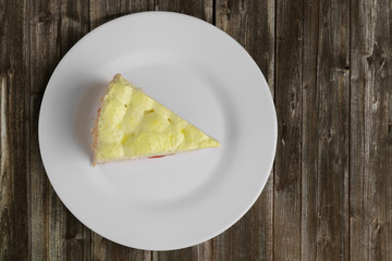 Top view of cherry cake with whipped cream on wooden table