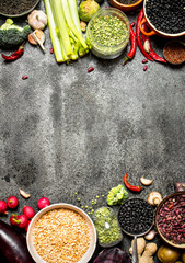 Organic Food. A variety of legumes with vegetables. On rustic background.