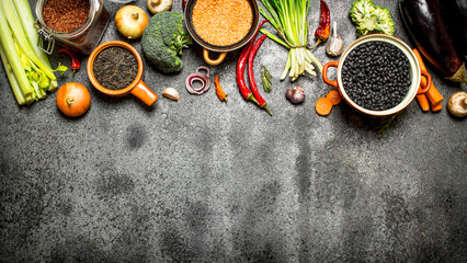 Organic Food. A variety of legumes with vegetables. On rustic background.