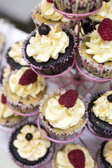 Delicious cupcakes with buttercream and fruits