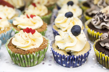 Delicious cupcakes with buttercream and fruits