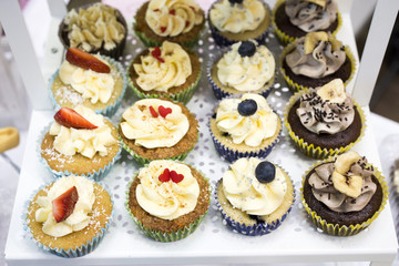 Delicious cupcakes with buttercream and fruits
