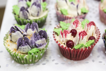 Delicious cupcakes with buttercream and fruits