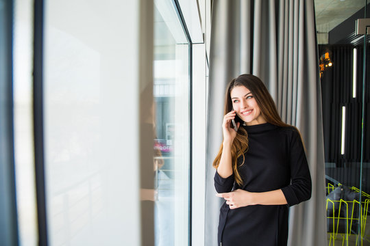 Smiling woman talking on phone in office
