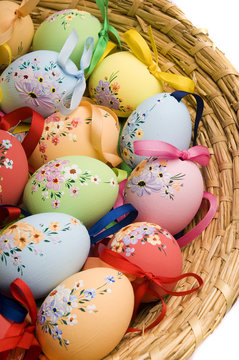 Basket with Easter colorful eggs over white background 