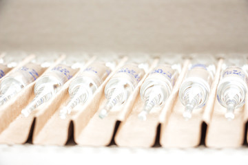Row of transparent medical ampules in package. Close up