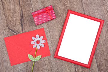 Picture frame and darling, envelope and flower on a wooden background