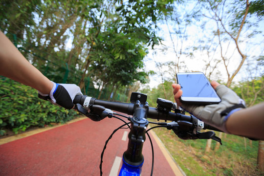 cyclist hands use gps navigator on smartphone while biking