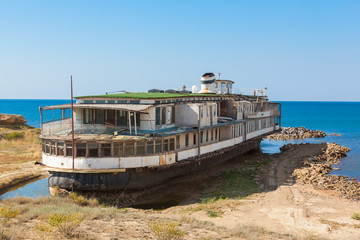 Fototapeta na wymiar old rusty wheel steamship on the sea shore