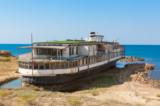 old rusty wheel steamship on the sea shore