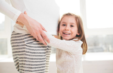 Pregnant woman and a child hugging