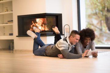Fototapeta premium multiethnic couple using tablet computer on the floor