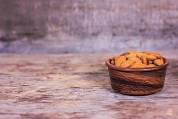 Almond. Almonds in a bowl on the old wooden background.