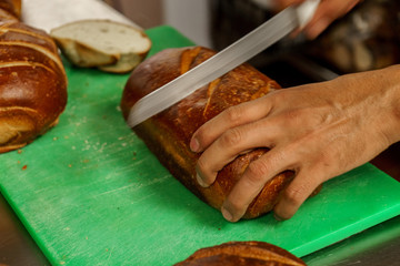 Freshly baked bread to be cut into a restaurant kitchen. - 139347087