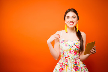 Beautiful smiling woman with mail envelope. Over orange background