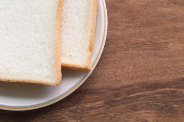 Fototapeta na wymiar Sliced bread in plate on wooden background.