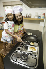 Asian mother and daughter enjoy making bakery cake at home