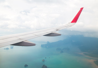 Fototapeta na wymiar Wing of an airplane flying above the ocean.