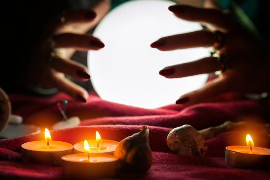 Hands of fortune teller around crystal ball