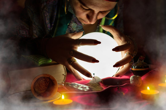 Gypsy woman fortune teller looking at crystal ball