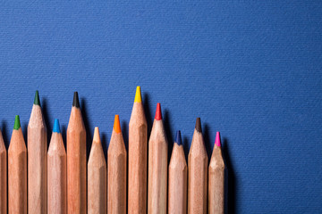 Row of colorful pencils on blue background