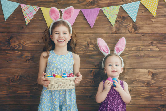 girls are holding basket with eggs