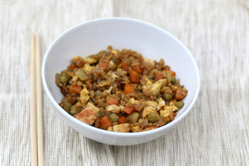 Fried rice with chicken, vegetables (peas, carrot, onion, garlic), egg and soy sauce. Selective focus.