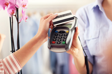 Closeup mid section of female customer paying in shop with credit card